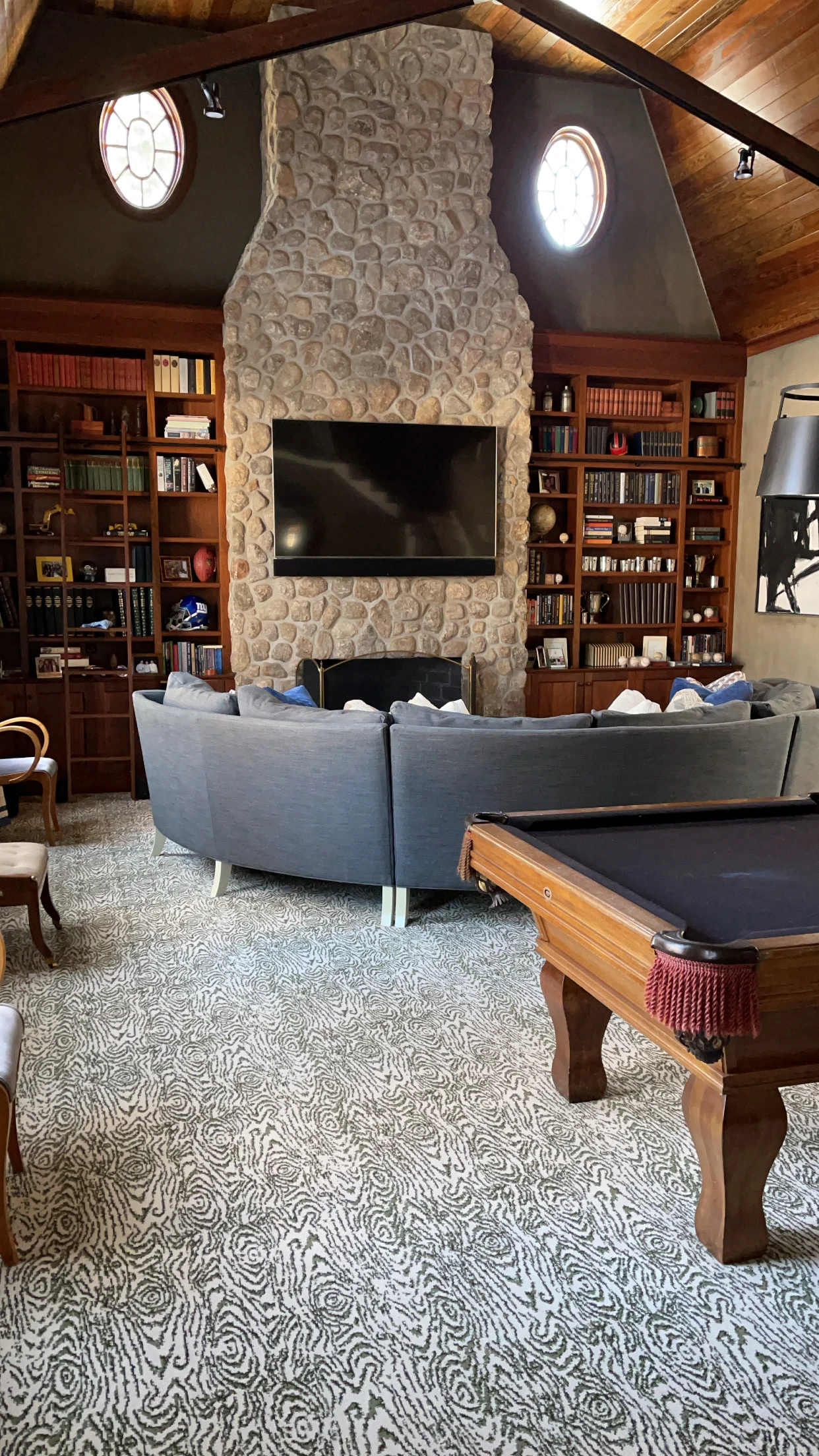 TV mounted above a warm stone fireplace