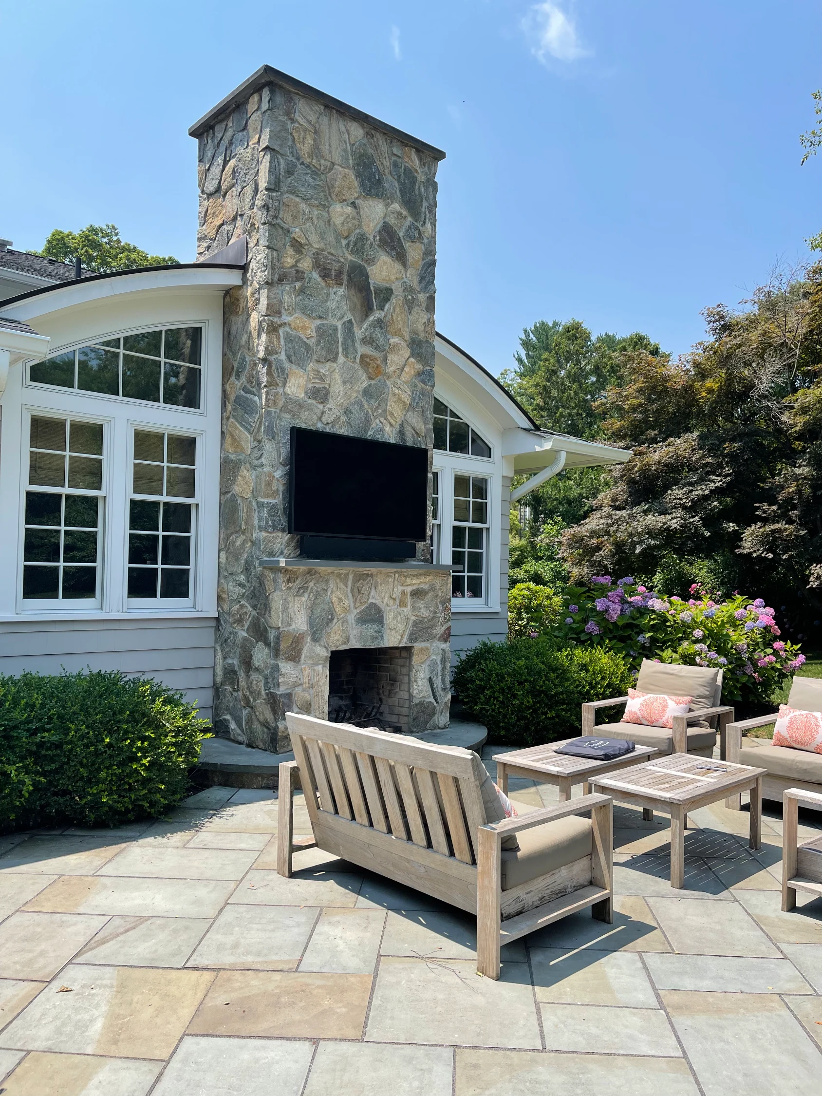 Outdoor living area with fireplace and flowerbeds